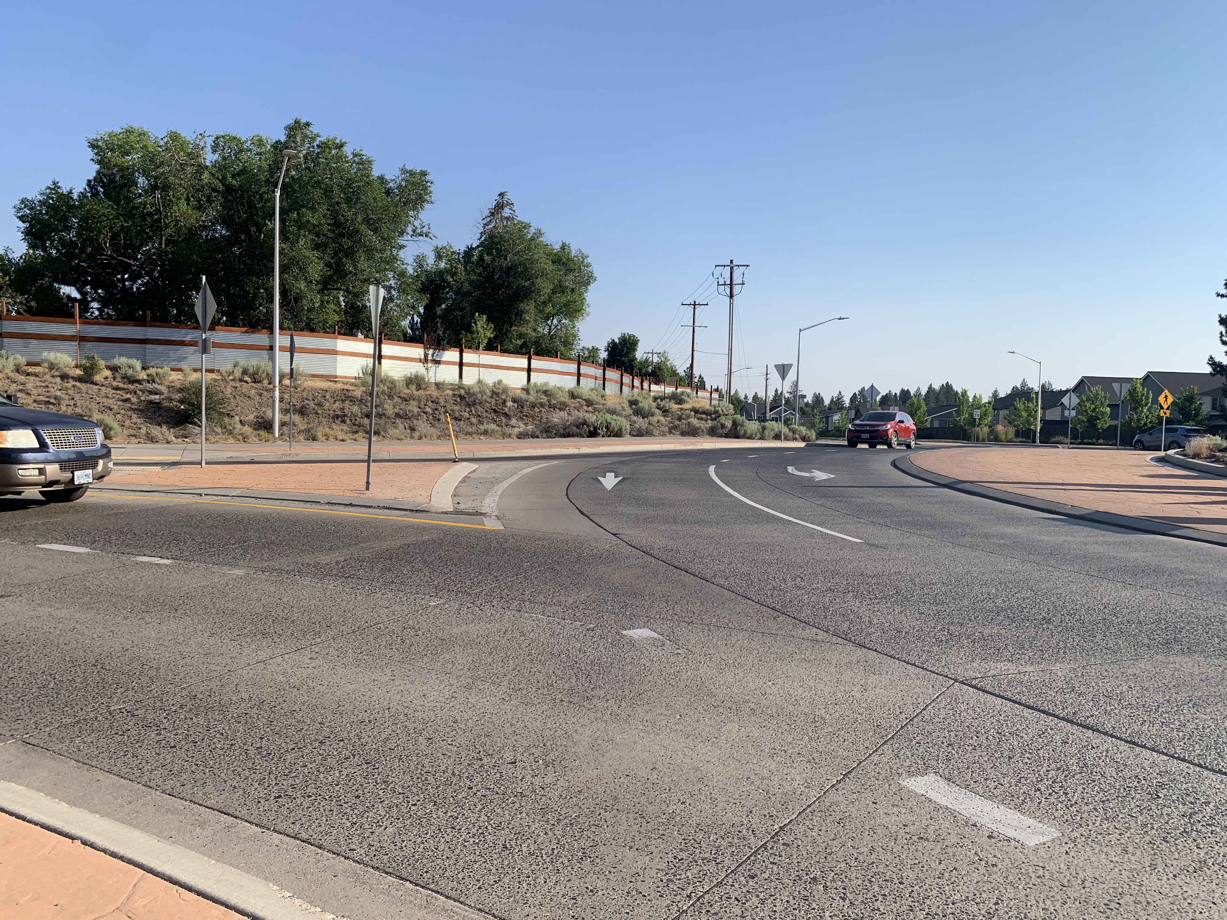 A car is entering the Reed Market Road and 15th Street intersection, while another car is traveling within the roundabout.