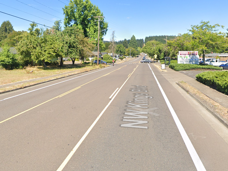 A straight, three-lane road on a sunny day extends into the distance.  