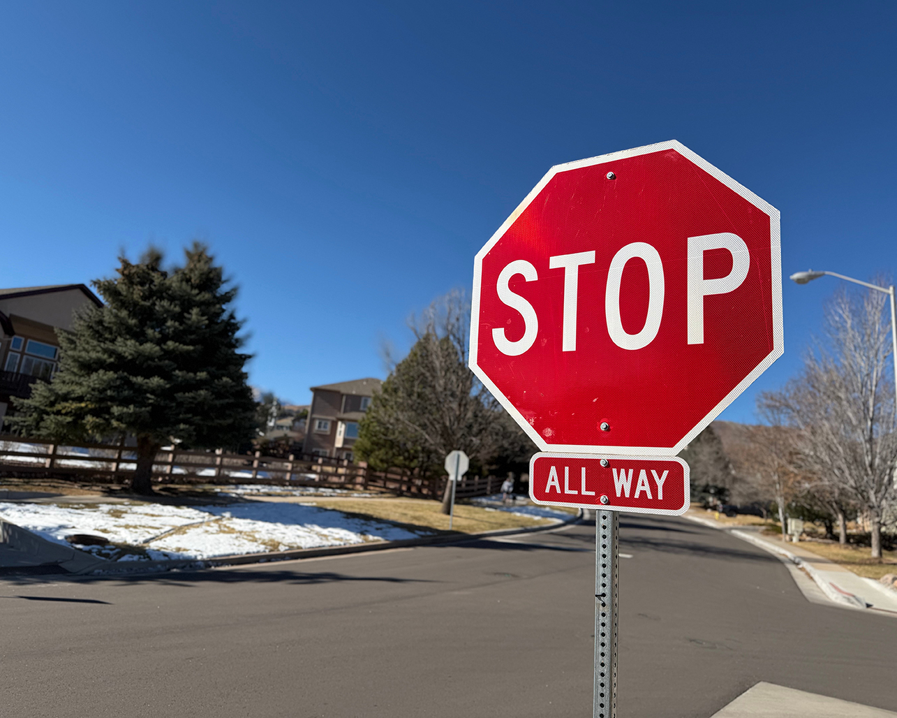 A stop sign with an 'All Way' plaque at a residential intersection.