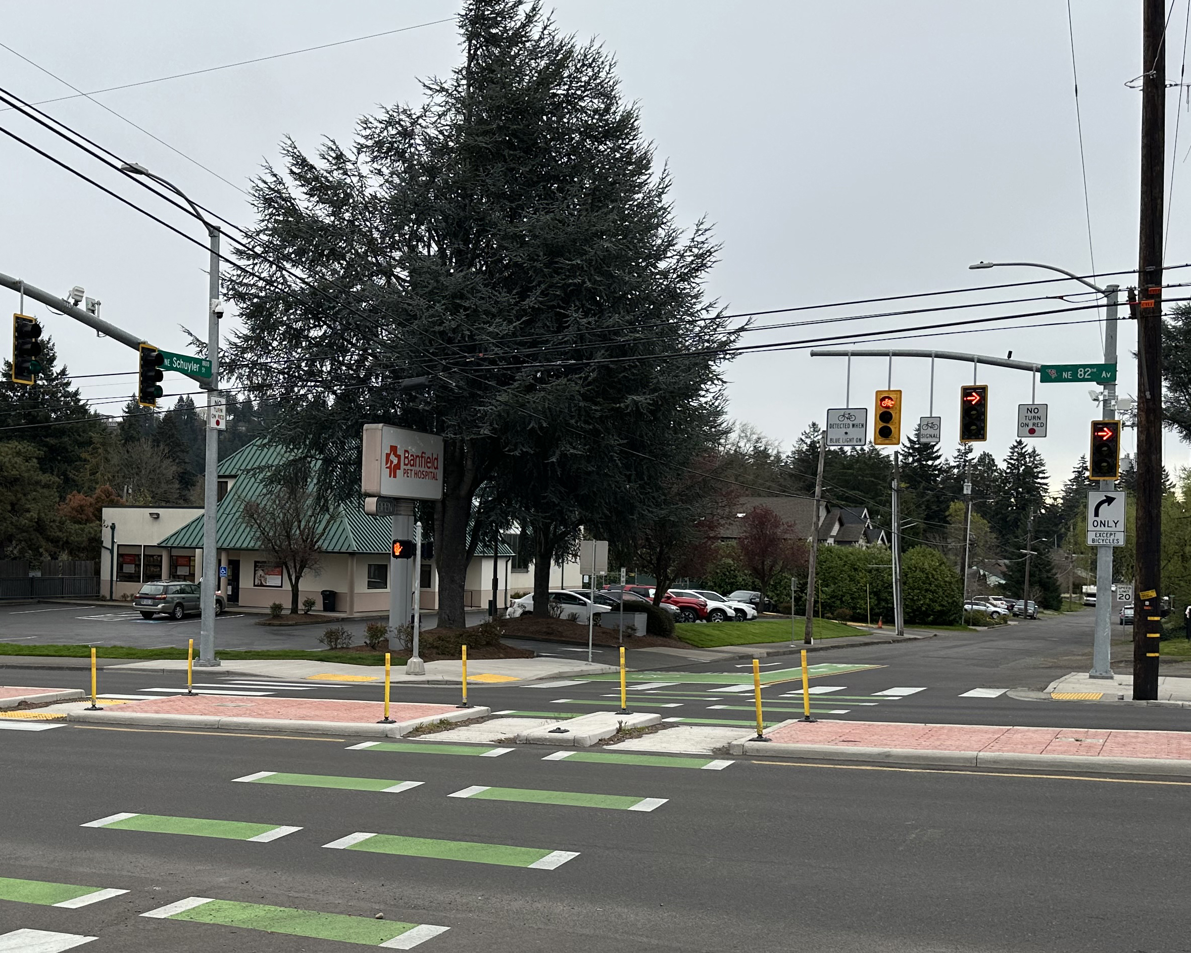 A signalized intersection with green-painted bike lane markings, crosswalks, a traffic signal, and a median restricting left turns.