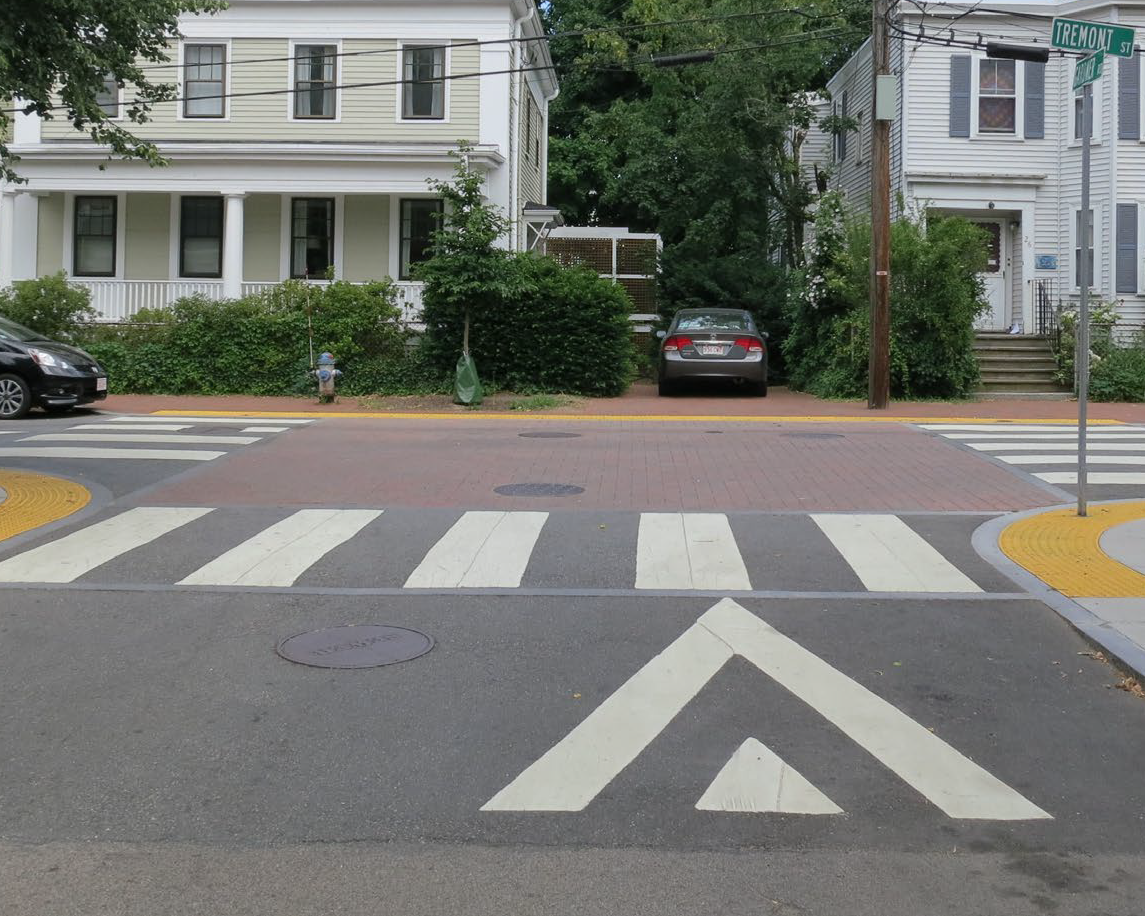 An intersection where the entire roadway surface is raised to sidewalk level, with colored pavement marking the crossing area.